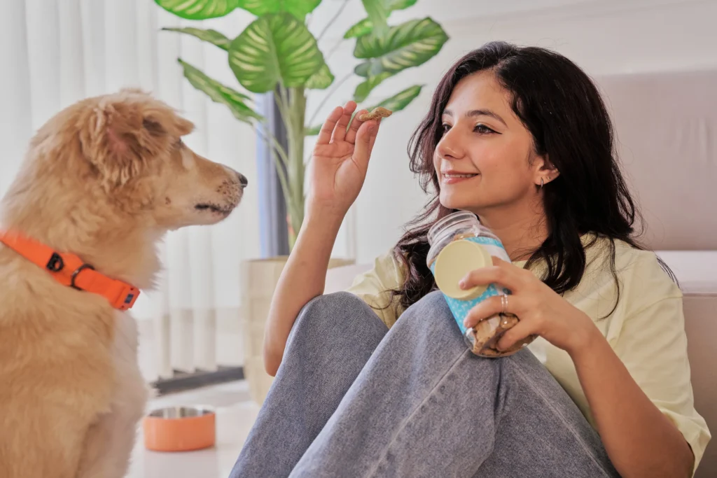woman giving dog treats from a dog bakery business